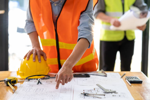 Young engineer architect sketching drawing builder bearings project plan building construction house site on documents, closed up cooperation corporate achievement planning design draw technology